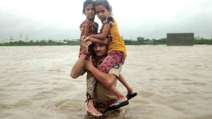 इस पुलिसकर्मी ने बाढ़ में कंधों पर 2 बच्चों को बैठाकर 1.5 किमी नदी पार कराई, सब जगह हो रही तारीफ
