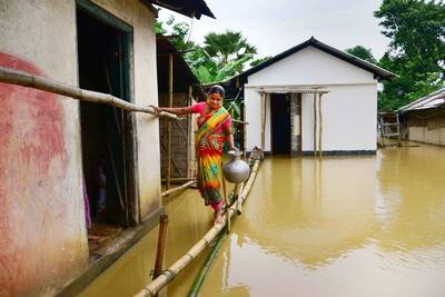 ये स्टंट नहीं है, बल्कि बाढ़ में डूबी घर-गृहस्थी के बीच जिंदा रहने की लड़ाई है, Assam flood की 10 तस्वीरें