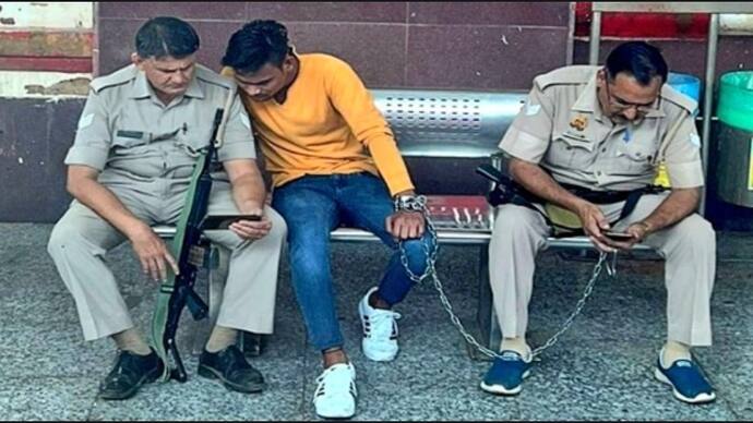 policemen holding criminal with chain and watching mobile